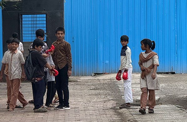A young girl watches her dream with a silent fire in her eyes—waiting for her chance to step into the ring. PC: Laher Gala